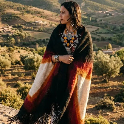 Femme enveloppée d'un châle coloré, bijoux tribaux, paysage rural en arrière-plan