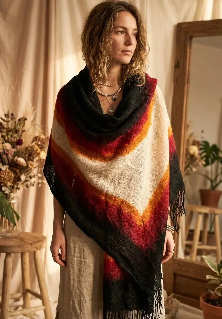 Femme portant un châle multicolore avec dégradé rouge, orange, blanc et noir dans une pièce décorée