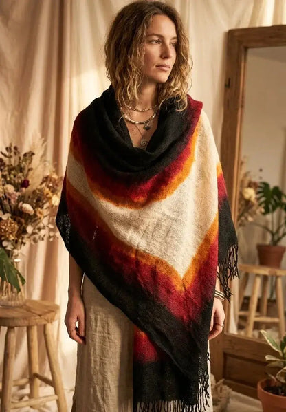 Femme portant un châle multicolore avec dégradé rouge, orange, blanc et noir dans une pièce décorée