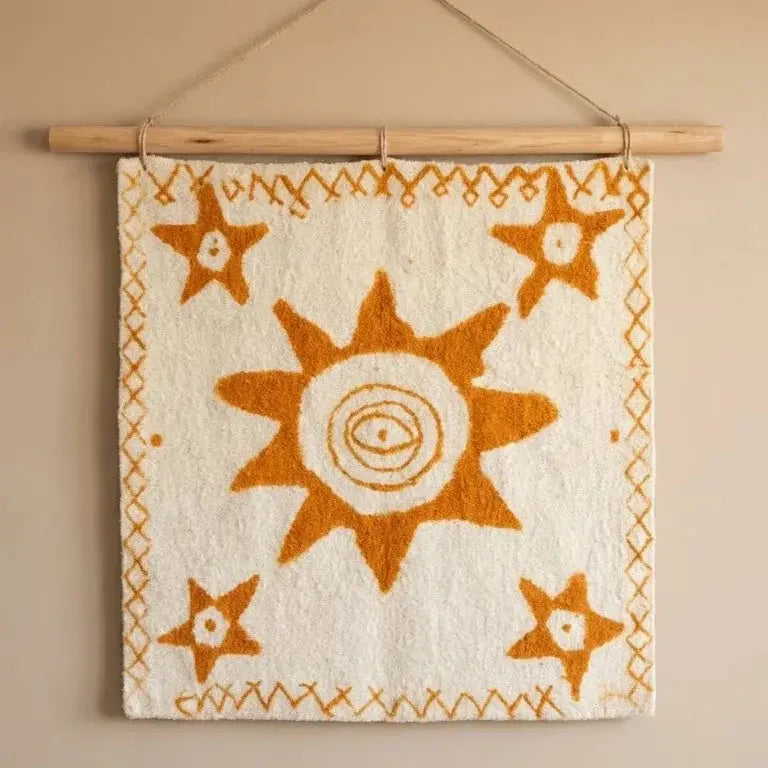 Tapis mural beige à motif soleil et étoiles orange suspendu sur un bâton en bois
